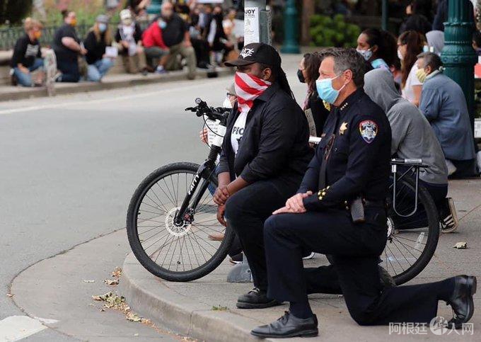 美警察为何用单膝跪地与和平抗议者站在一起？