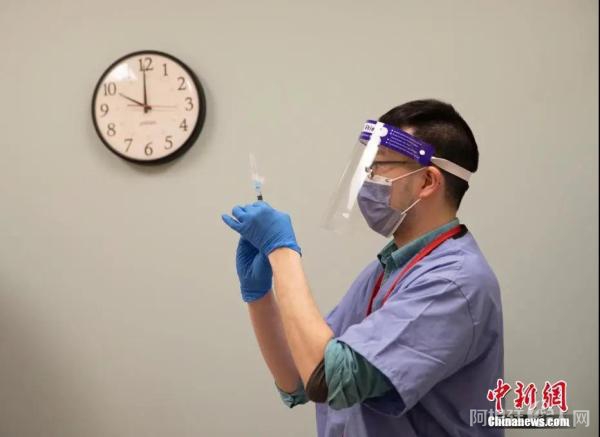 资料图：医护人员准备为社区居民接种新冠疫苗。中新社记者 刘关关 摄