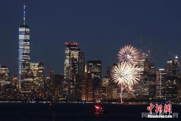 当地时间6月15日晚，纽约州多地燃放焰火并将十余处地标建筑点亮蓝色和金色灯光，庆祝新冠疫苗接种达阶段目标。中新社记者 廖攀 摄