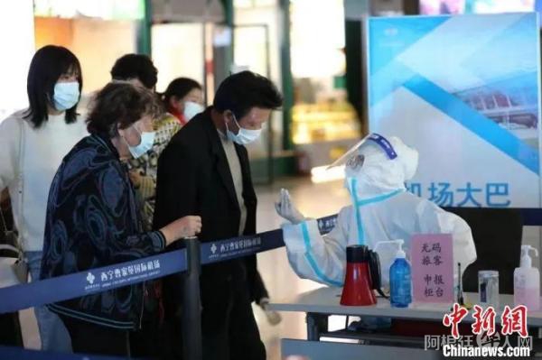资料图:图为机场防疫工作人员为旅客测温检查。 李泽中 摄 资料图:图为机场防疫工作人员为旅客测温检查。 李泽中 摄
