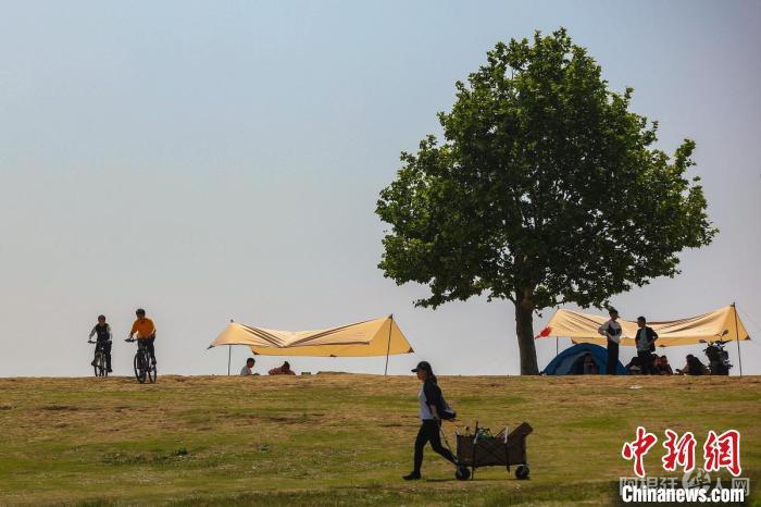 帐篷下聊天，帐篷外骑行。　泱波 摄
