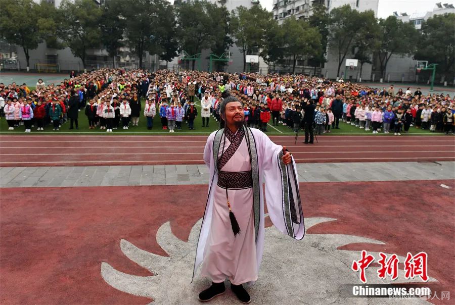 在屈原故里湖北省秭归县，“屈原”扮演者带领小学生诵读屈原作品《离骚》。中新社发 王辉富 摄