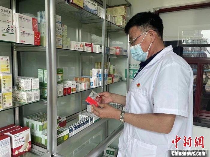 丁晓东查看药房的药品 苍雁 摄 丁晓东查看药房的药品 苍雁 摄
