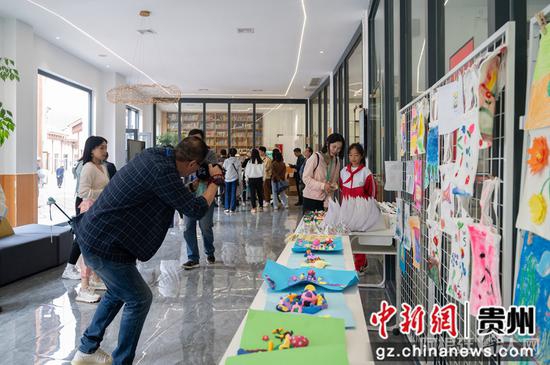 图为9月21日“华文媒体侨行贵州”媒体团一行在毕节市赫章县金银山易地扶贫搬迁社区少儿活动中心调研采访。唐哲 摄