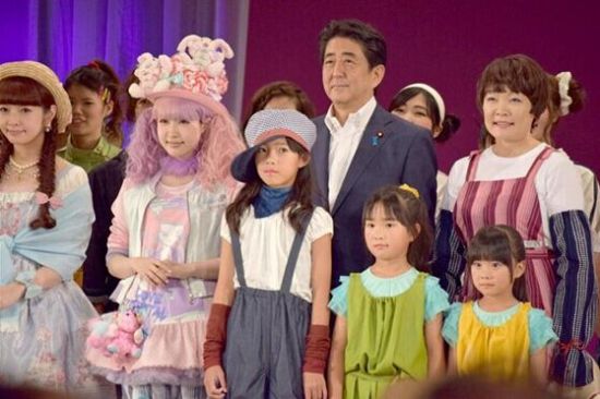 安倍昭惠身穿扎腿劳动裤，以&ldquo;农家女孩&rdquo;的形象同安倍手挽手同登舞台